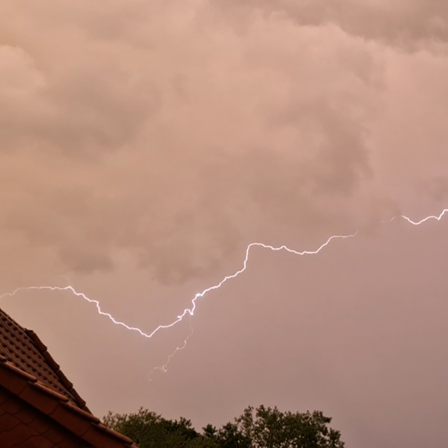 Ein Blitz zuckt über einen gelblichen Himmel