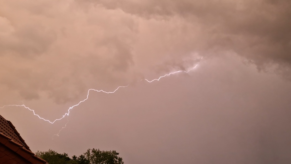 Ein Blitz zuckt über einen gelblichen Himmel