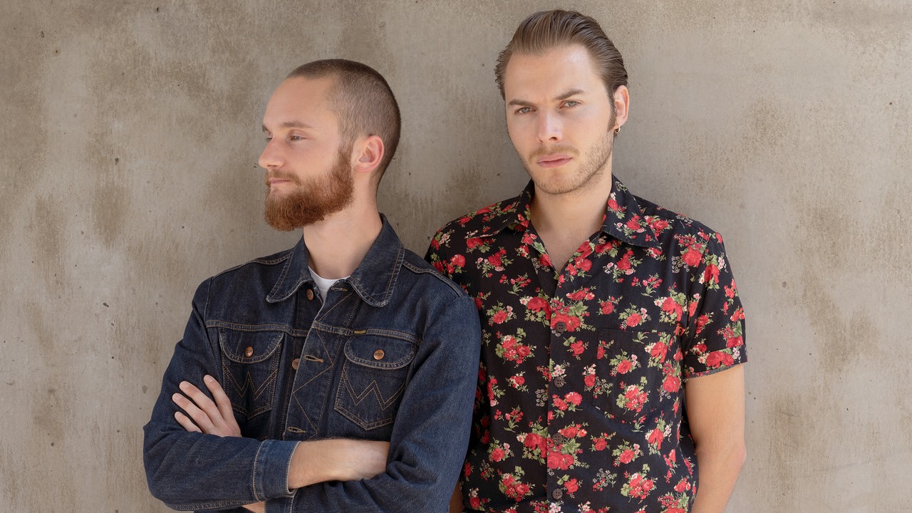 Zwei jungen Männer der Band BRTHR stehen an einer Wand.