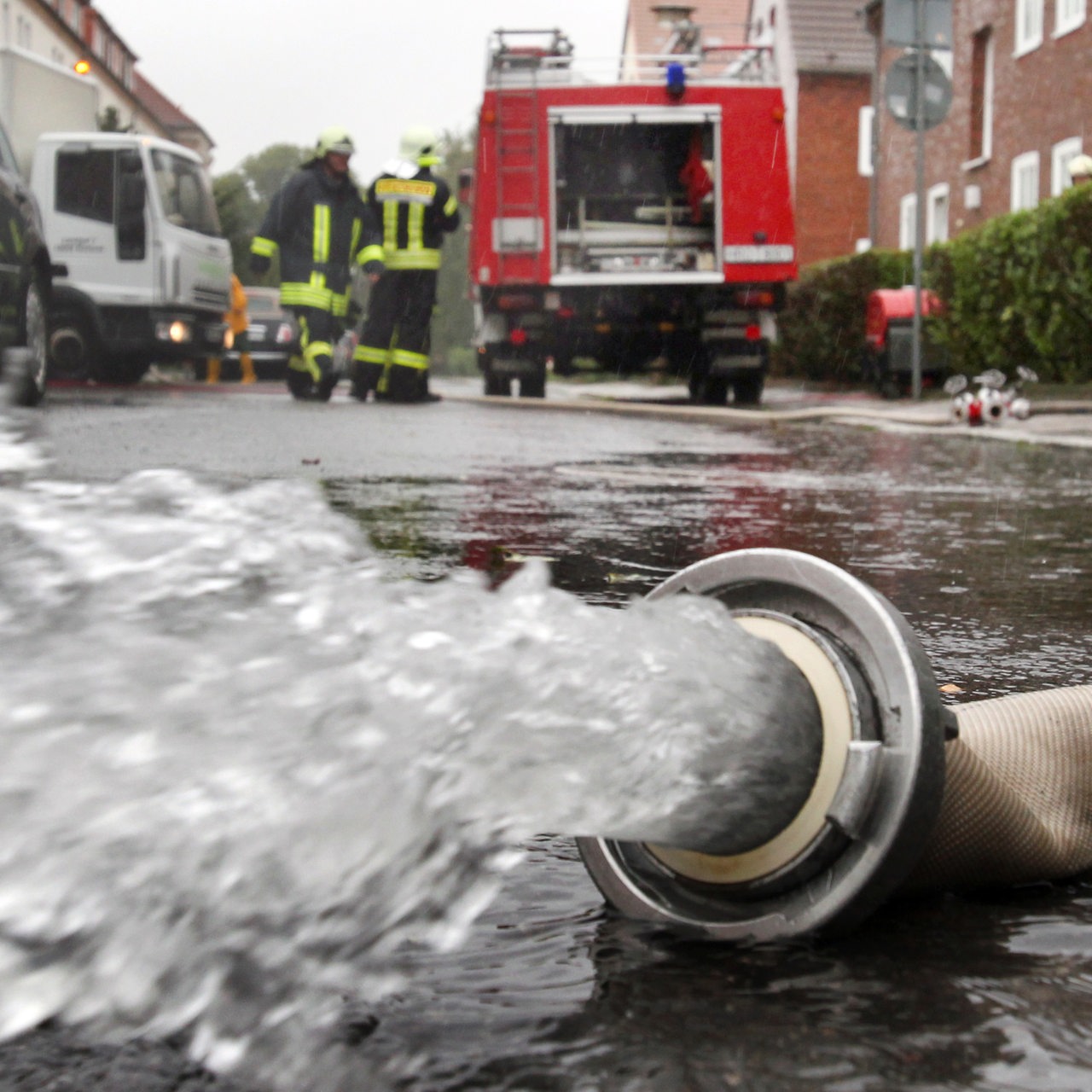 Die Feuerwehr pumpt einen Keller aus. Aus einem Schlauch sprudelt Wasser.