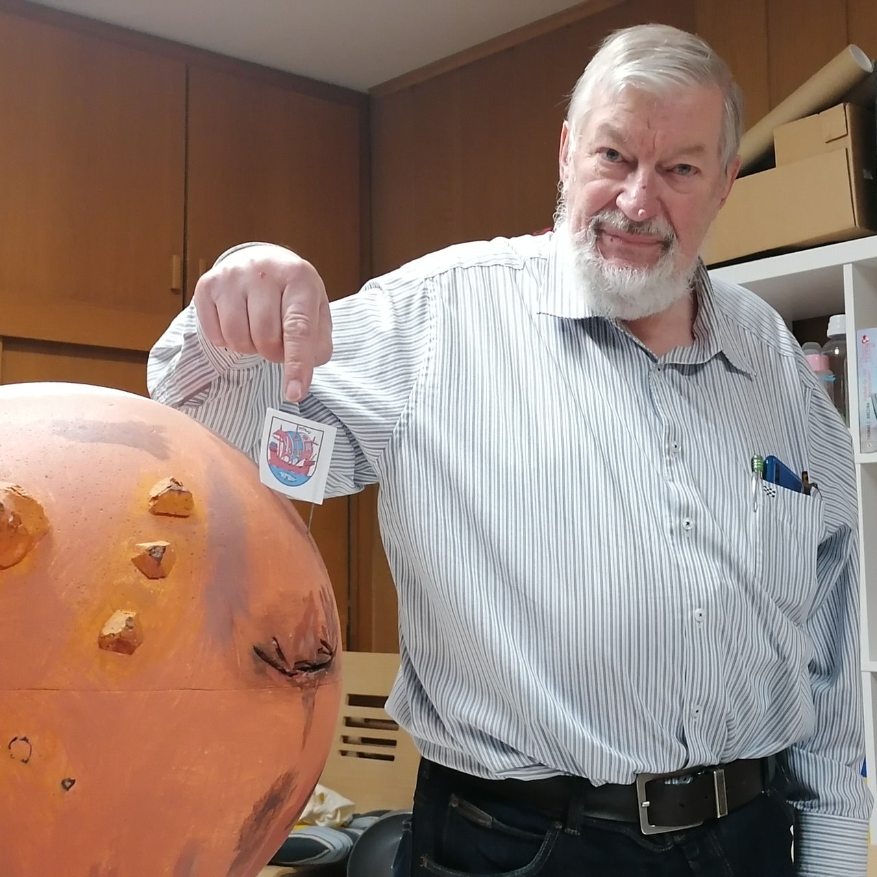 Günter Neumann mit Mars-Modell, auf dem das Bremerhavener Wappen gesteckt ist.