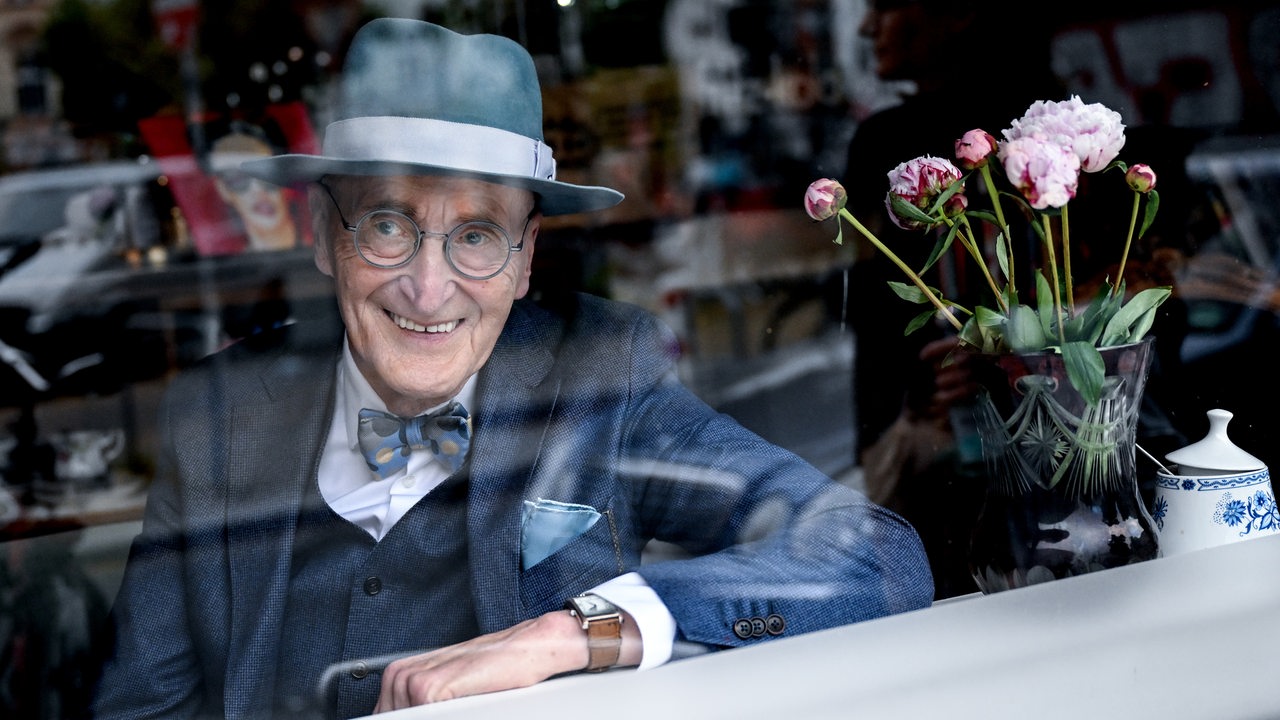 Günther Krabbenhöft sitzt lächelnd an einem Fenster und schaut heraus