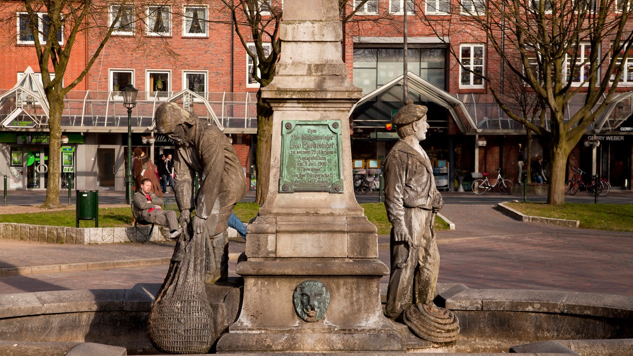 ein Brunnen aus Sandstein mit zwei Figuren an der Seite