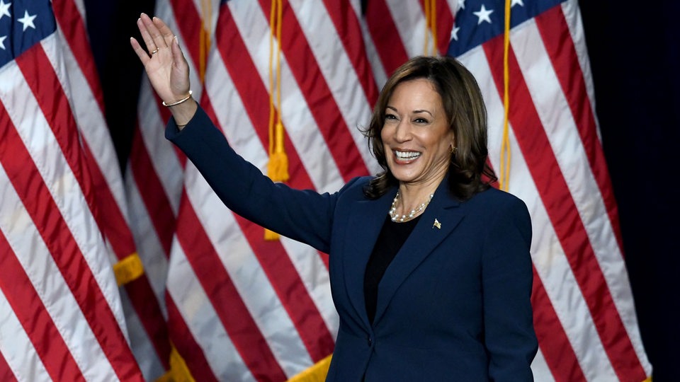 Kamala Harris lächelt und winkt.