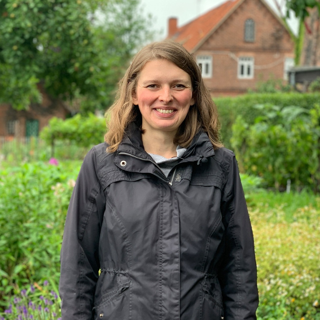 Eine Frau steht in einem großen Garten